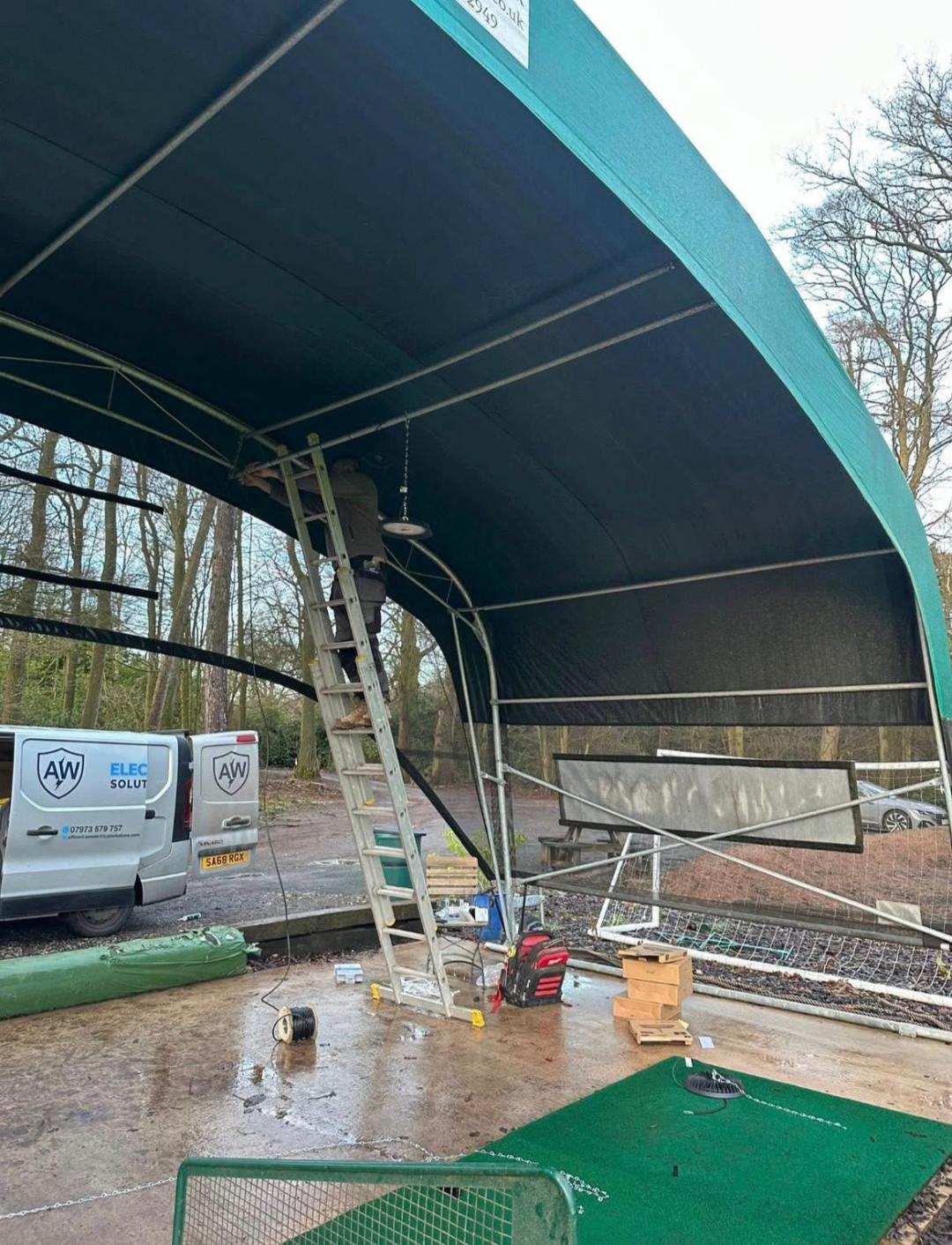 LED floodlight installation underway from inside the covered range